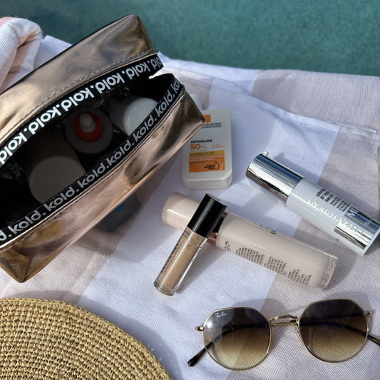 Open KOLD insulated make-up bag with sunscreen, foundation and various makeup